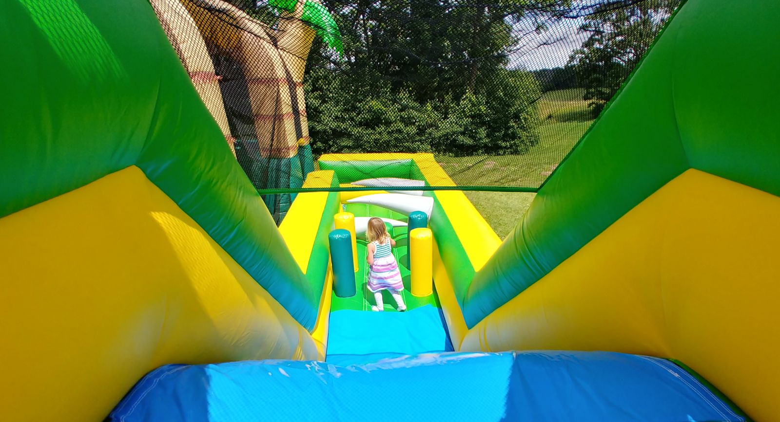 Young girl on tropical inflatable obstacle course
